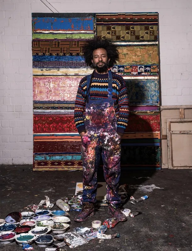 Tegene Kunbi in his studio in front of a painting